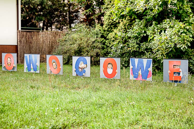 Napis owocowe na trawniku przed wejściem do przedszkola.